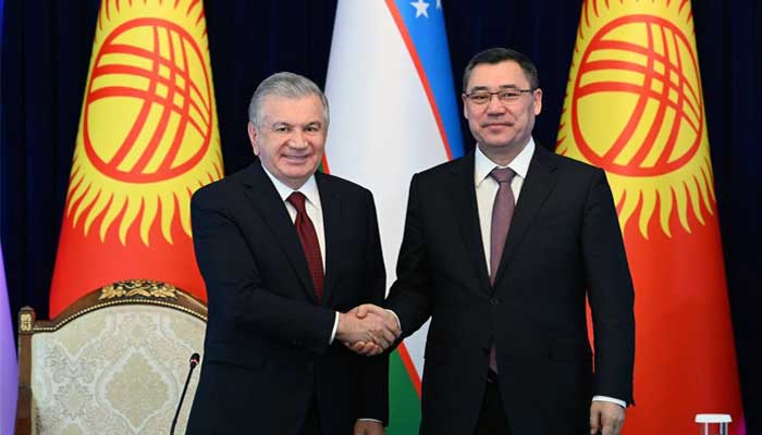 The presidents of Kyrgyzstan (right) and Uzbekistan (left) shake hands.