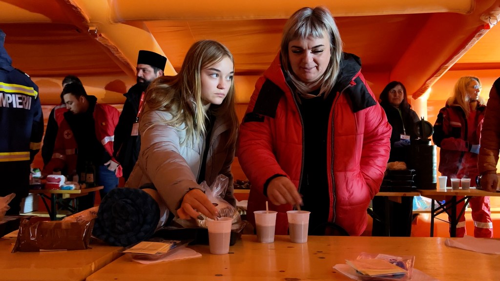 Larysa Kirilenko from Donetsk and her daughter take a snack on at a waystation en route to Bucharest. Larysa Kirilenko from Donetsk and her daughter take a snack on at a waystation en route to Bucharest.