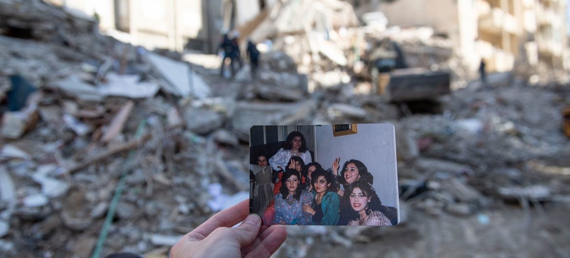 In Jableh district in northwestern Syria, a photo of a family is held up in front of the building where they used to live. In Jableh district in northwestern Syria, a photo of a family is held up in front of the building where they used to live.