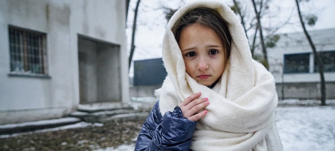 An 8-year-old girl poses in front of a building in Irpin, Ukraine where her mother and sister share a small room. An 8-year-old girl poses in front of a building in Irpin, Ukraine where her mother and sister share a small room.
