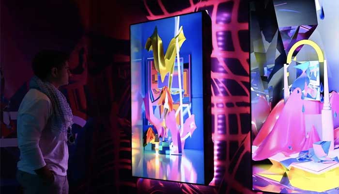 400 artists from 40 countries will present their work A man looks at artworks at Art Dubai 2023.