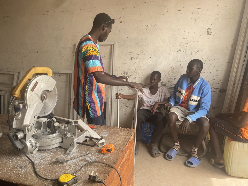 Amadou Jobe, a returning migrant, trains apprentices in a workshop in Banjul, The Gambia.