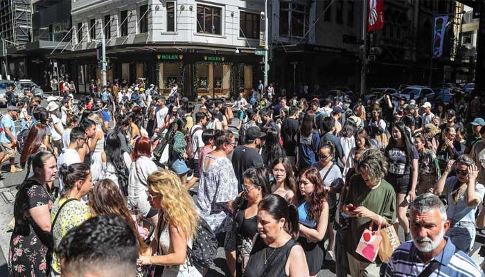 Pedestrians crowd a Melbourne street