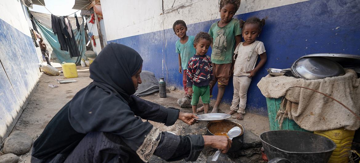 A mother-of-nine, who is suffering from malnutrition, cooks a meal for her children in a displaced camp in Aden, Yemen. A mother-of-nine, who is suffering from malnutrition, cooks a meal for her children in a displaced camp in Aden, Yemen.
