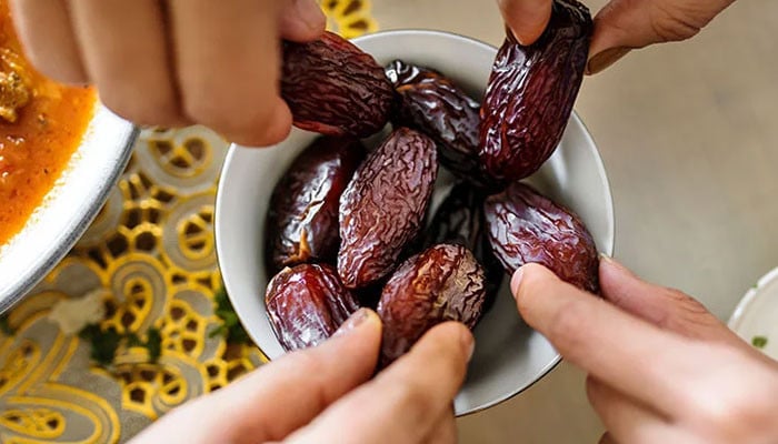 Why is it important to eat the dates used to break the fast at Iftar?