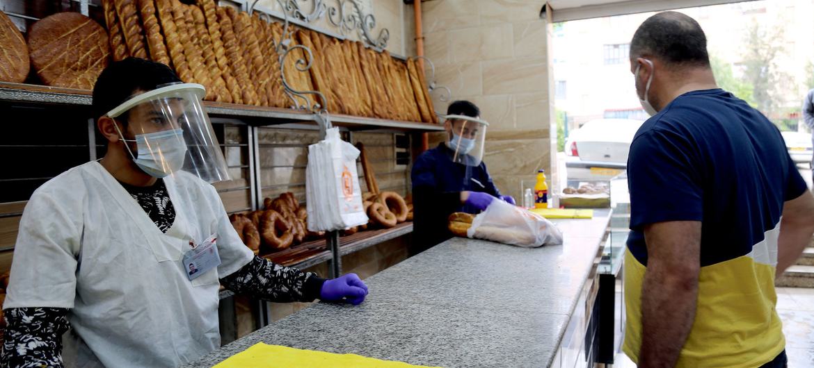 Shop workers sell bread at a bakery in Constantine, Algeria during the COVID-19 pandemic.