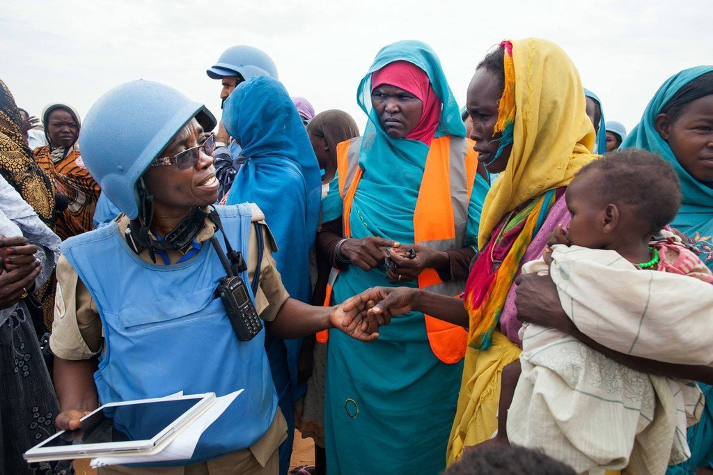 UNAMID police officer Grace Ngassa (Tanzania) and Community Policing Volunteer Jazira Ahmad Mohammad interact with a woman in the Zam Zam camp for internally displaced persons in North Darfur. UNAMID police officer Grace Ngassa (Tanzania) and Community Policing Volunteer Jazira Ahmad Mohammad interact with a woman in the Zam Zam camp for internally displaced persons in North Darfur.