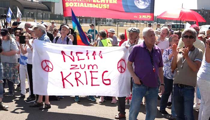 Protesters protest outside the airbase against the NATO exercise.