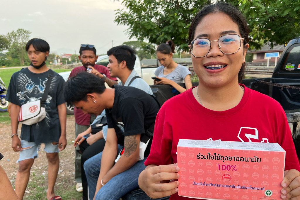 Baitoey , a peer educator for sexual and reproductive health, prepares to hand out condoms to a group of young men. Baitoey , a peer educator for sexual and reproductive health, prepares to hand out condoms to a group of young men.