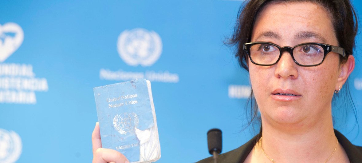 Elpida Rouka, survivor of the bombing of the Canal Hotel in Baghdad on 19 August 2003 holds her damaged UN Laissez-Passer. Elpida Rouka, survivor of the bombing of the Canal Hotel in Baghdad on 19 August 2003 holds her damaged UN Laissez-Passer.