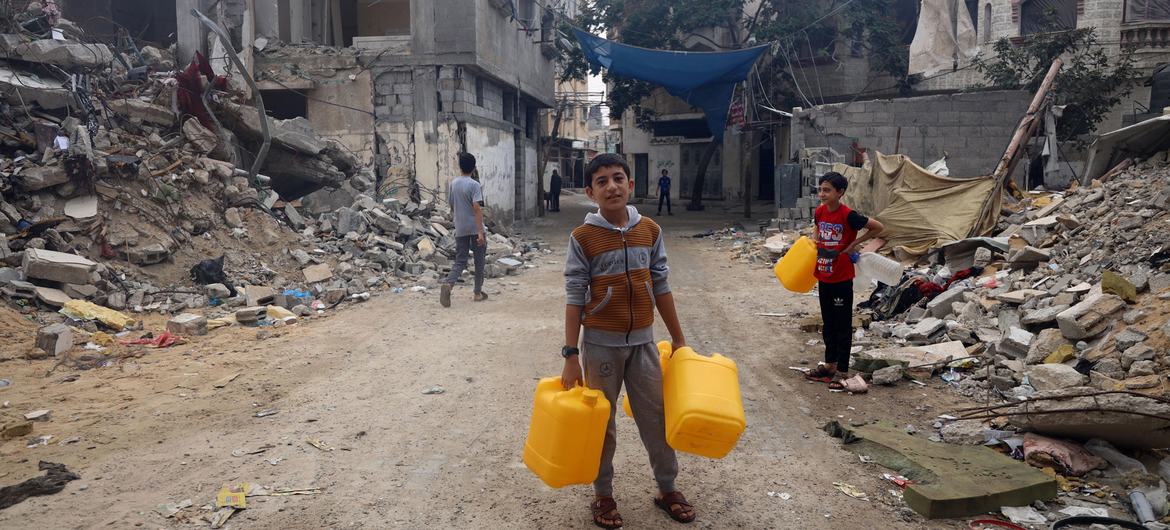 A boy collects water in a bombed neighbourhood in Gaza. A boy collects water in a bombed neighbourhood in Gaza.