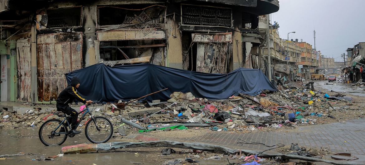 A boy cycles through the heavily bombarded Asqola neighbourhood of Gaza City.