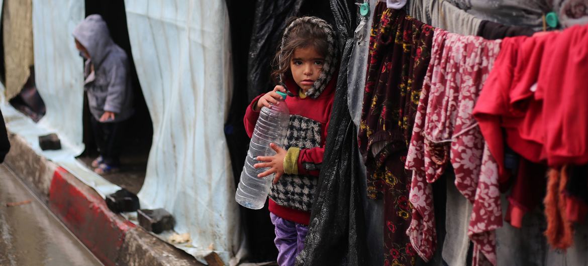 A girl stands in front of her shelter in the city of Rafah. A girl stands in front of her shelter in the city of Rafah.
