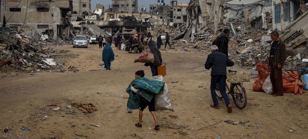 People carry their possessions through Khan Younis in the southern Gaza Strip. People carry their possessions through Khan Younis in the southern Gaza Strip.