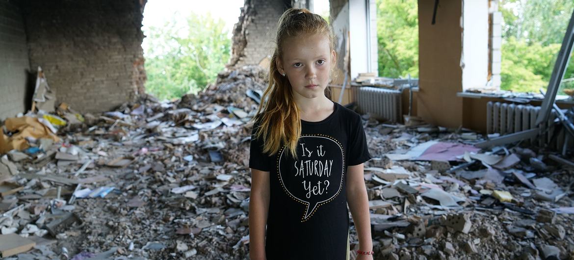 Eight-year-old Anya stands amidst rubble in her damaged school in Buzova, Ukraine. Eight-year-old Anya stands amidst rubble in her damaged school in Buzova, Ukraine.