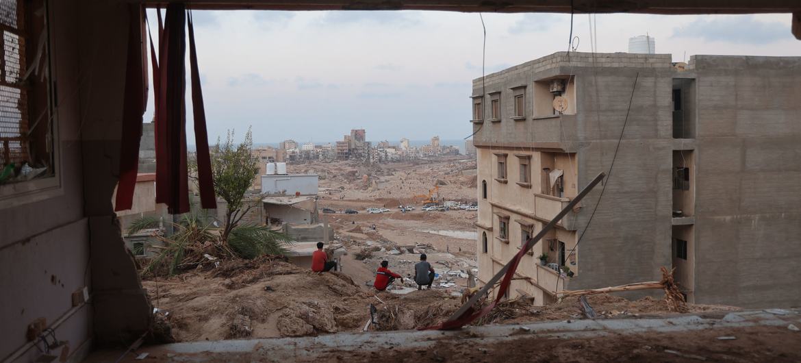 People gather outside a flood-damaged apartment building in Derna, eastern Libya. People gather outside a flood-damaged apartment building in Derna, eastern Libya.