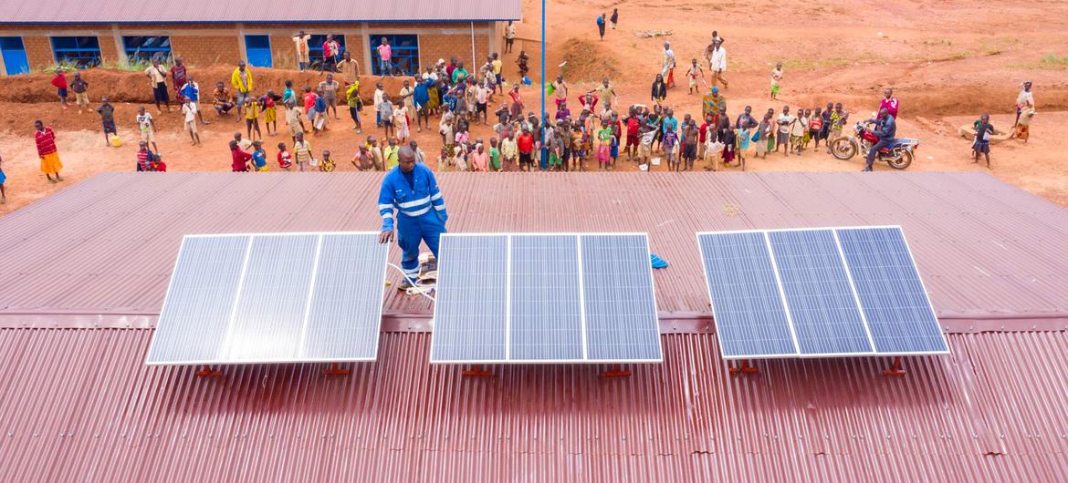 A technician installs solar panels on a health centre in Burundi.