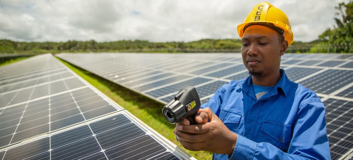 Solar panels being maintained by a worker at a photovoltaic farm in Mauritius.