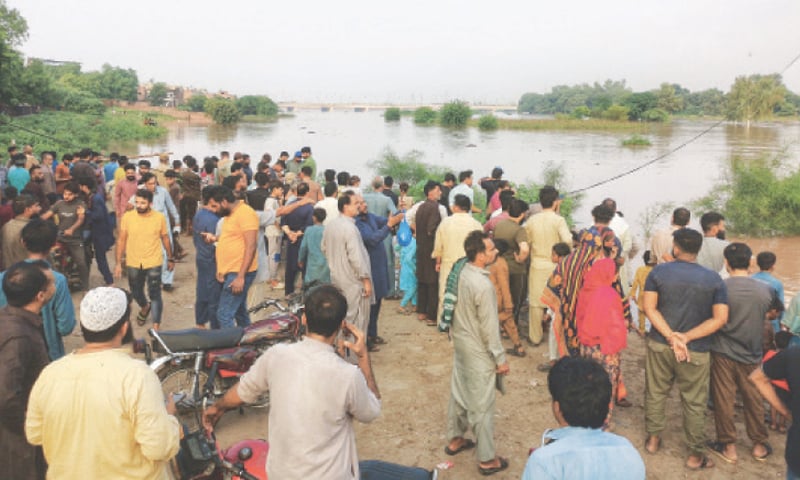 Residents of Farrukhabad stand on the banks of the river Ravi after the floodwater enters their locality. — White Star / Dawn Residents of Farrukhabad stand on the banks of the river Ravi after the floodwater enters their locality. — White Star / Dawn